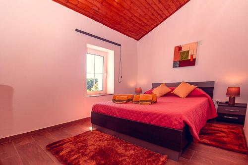 een slaapkamer met een bed met rode lakens en een raam bij Moinho de Palma de NaturAlegre in Alegrete