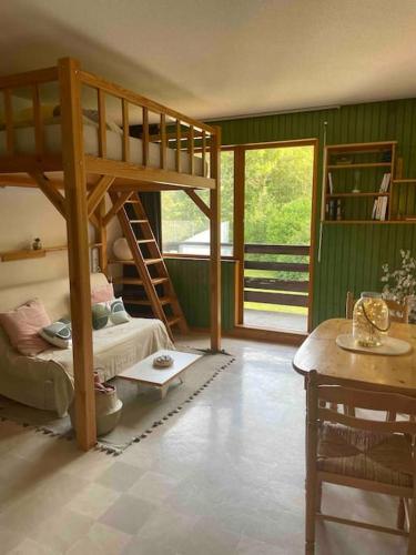 a room with a bunk bed and a table at Studio près du lac in Malbuisson