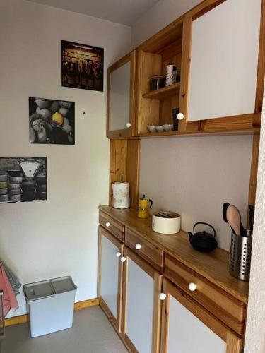 a kitchen with wooden cabinets and a counter top at Studio près du lac in Malbuisson