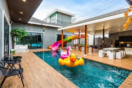 una piscina con patos inflables en una casa en White Cloud & Brown Sand Luxury Pool Villa Cha-Am, en Cha Am