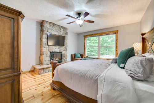 1 dormitorio con 1 cama y chimenea de piedra en Bellaire Cabin at Shanty Creek Near Schuss Mtn! en Bellaire