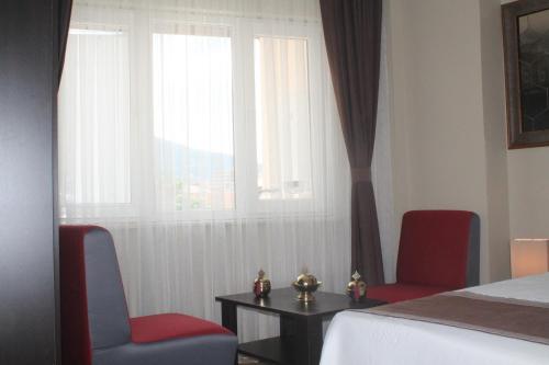 a bedroom with two chairs and a table and a bed at Lena Central Flats in Bursa