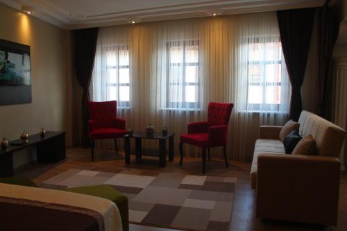 sala de estar con sillas rojas, sofá y ventanas en Lena Central Flats, en Bursa