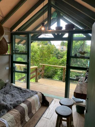 a bedroom with a large bed and a wooden deck at Rancheria Loft Chalet, lago privado in Rionegro