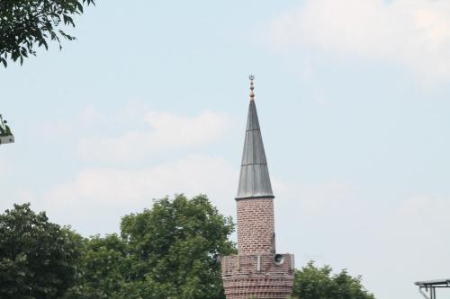 a steeple of a church with trees in the foreground at Lena Central Flats in Bursa