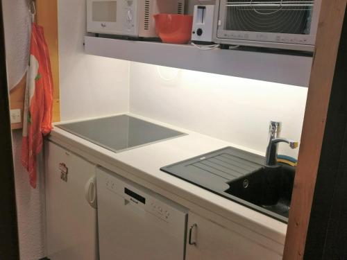 une cuisine avec un évier et un micro-ondes dans l'établissement Appartement cosy au centre avec balcon et Wifi gratuit - FR-1-346-435, à Arc 1800