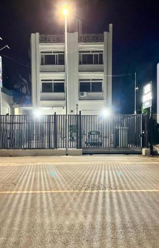 a fence in front of a white building at night at Life Hotel in Casalnuovo di Napoli