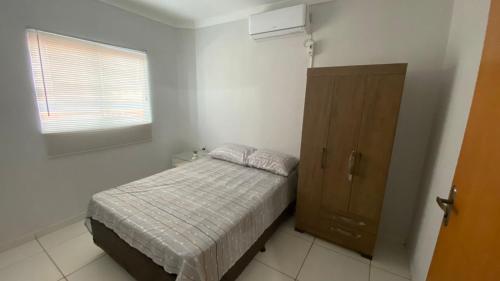 um pequeno quarto com uma cama e uma janela em Apartamento Daia Prox Caoa em Anápolis