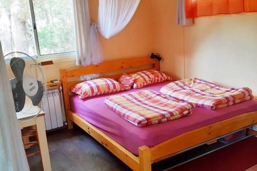 um quarto com uma cama de madeira e 2 almofadas em Cabaña, separates Gästehaus mit Pool und Garten em Punta del Este