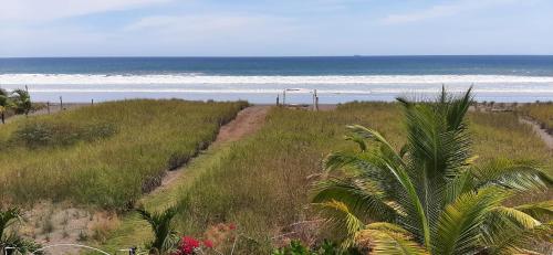 a dirt road leading to a beach with the ocean at Beautiful oceanfront townhouse LA Barqueta Nice Las Olas resort in Guarumal