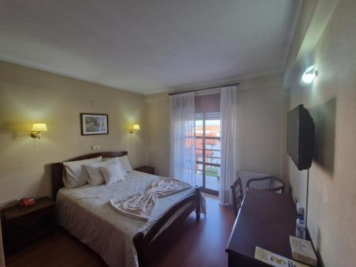 una camera d'albergo con letto e finestra di Hotel Peninsular a Monte Real