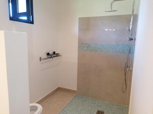 y baño con ducha y puerta de cristal. en Villa Blue, en Boukot Ouolof