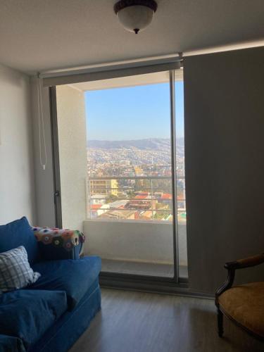 sala de estar con sofá azul y ventana grande en Placeres, en Valparaíso