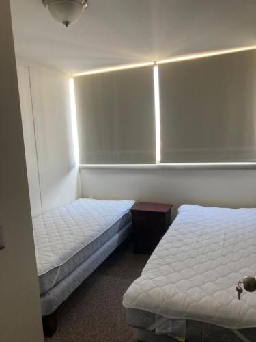 1 dormitorio con 2 camas y una luz en la pared en Placeres, en Valparaíso