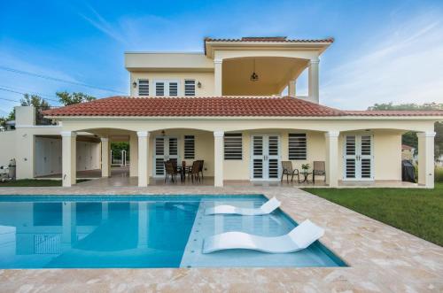 a house with a swimming pool in front of it at Casa Cielo in Rincon