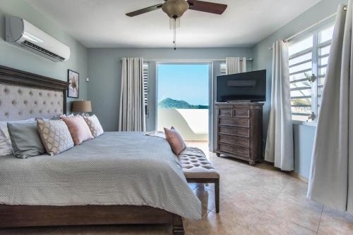 a bedroom with a bed and a flat screen tv at Casa Cielo in Rincon