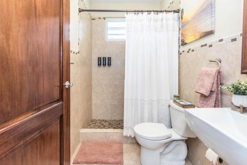 a bathroom with a toilet and a sink and a shower at Casa Cielo in Rincon