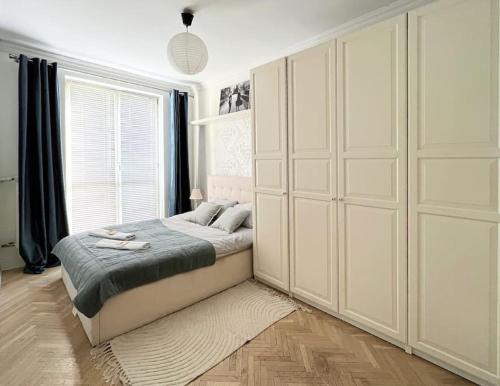 a bedroom with a bed and a large window at Warsaw Concierge Grochowska in Warsaw