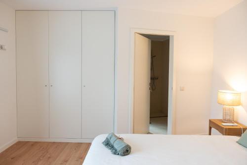 a bedroom with white walls and a bed and a lamp at Quinta da Ribeirinha - Douro River in Paços de Gaiolo