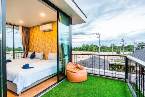 a bedroom with a bed on a balcony at White Cloud & Brown Sand Luxury Pool Villa Cha-Am in Cha Am