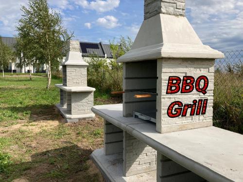 a brick oven with a sign that says big grill at Domki Ostoja - nad Bałtykiem - cisza i piękno natury in Zastań
