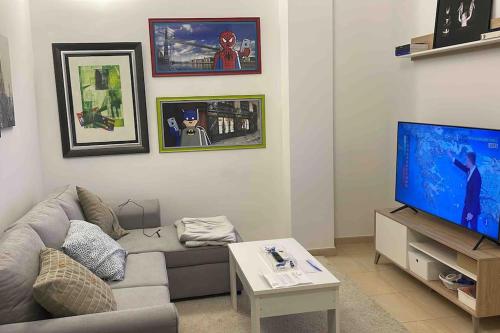 sala de estar con sofá y TV de pantalla plana en Apartamento recién reformado en Barajas Pueblo en Madrid