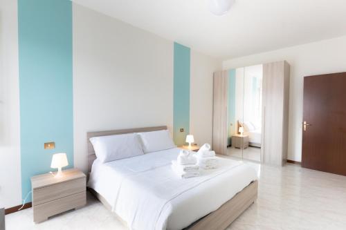 a bedroom with a large white bed with towels on it at Carola's place - by Relais Di Giada in Como
