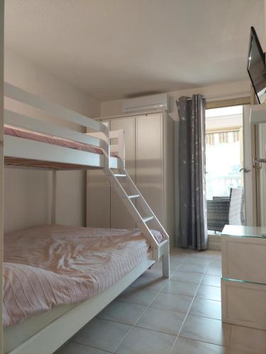 une chambre avec un lit superposé avec une échelle dans l'établissement Côté mer, à Sainte-Maxime