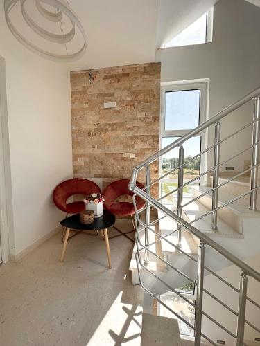 a living room with two red chairs and a table at Apartmens Xhenis Lux in Ulcinj