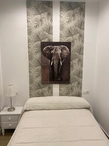 una foto de un elefante en una pared sobre una cama en Bonito y acogedor apartamento pleno centro Granada, en Granada