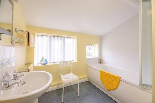 a bathroom with a white sink and a tub and a sink at The Old Shop, No 12 in Framlingham