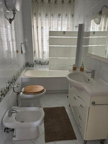een witte badkamer met een toilet en een wastafel bij casa vacanza Maria in Napels