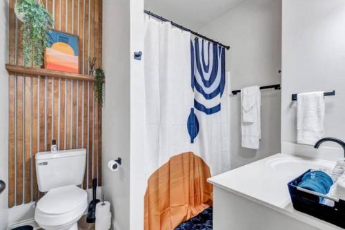 a bathroom with a toilet and a shower curtain at Stylish & Romantic Home, Long-term friendly, King in Baton Rouge