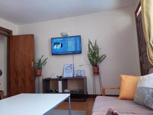sala de estar con sofá y TV en la pared en Zani Suites, en Nakuru