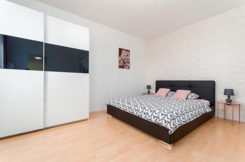 a bedroom with a bed with pink pillows on it at Millenium Apartment Self check-in Faktura in Rzeszów