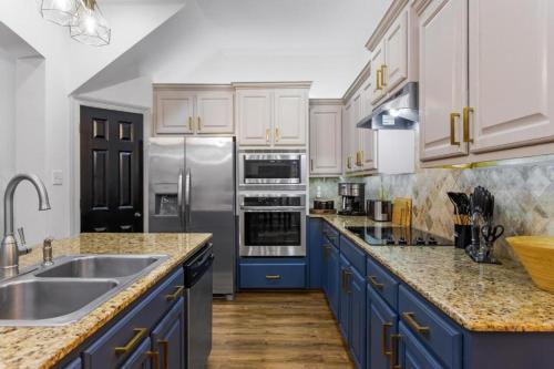 a kitchen with blue cabinets and stainless steel appliances at Beautiful 3bed 3bath min from LSU and Mall in Baton Rouge