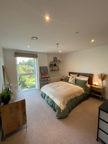 a bedroom with a large bed and a window at Stylish 1BR Apartment Next To Hampstead Heath in London