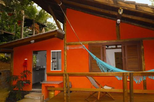 a house with a hammock in front of it at Casas Temporada Aldeia Niura Opy in Florianópolis