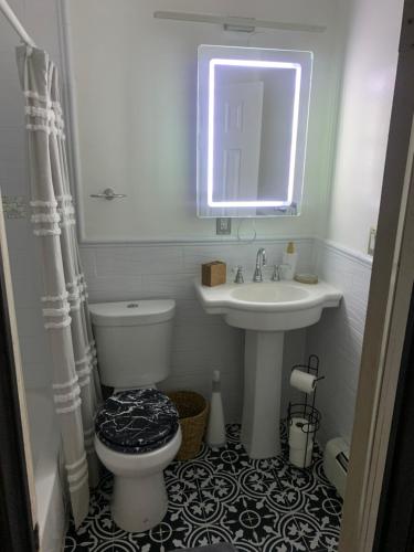 a bathroom with a sink and a toilet and a mirror at Brooklyn Red Door in Brooklyn