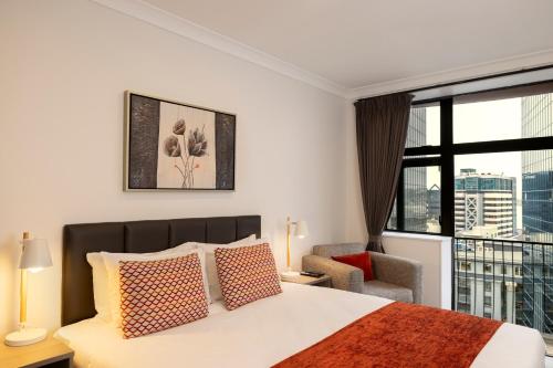 a bedroom with a bed and a large window at Quest On The Terrace Serviced Apartments in Wellington