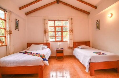 a bedroom with two beds and a window at Eco Hacienda Roman in Machu Picchu