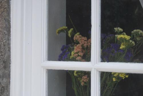 a window with a bunch of flowers in a vase at Home Near the Clouds - Refúgio in Nordeste