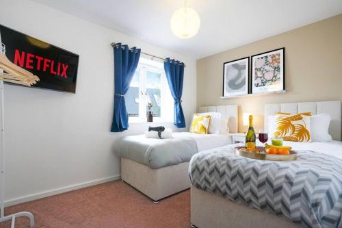 a bedroom with two beds and a table with fruit on it at Appledore House - Close to City Centre - Free Parking, Fast Wifi, Private Garden and Smart TV with Netflix by Yoko Property in Milton Keynes