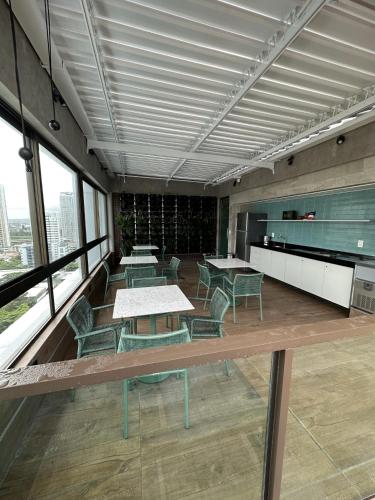a room with tables and chairs in a building at Boa Viagem - FLAT ROOFTOP 470 - NOVO in Recife