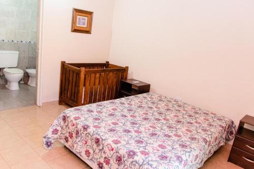 a bedroom with a bed and a toilet at Cabañas Susurros del Río in Trapiche