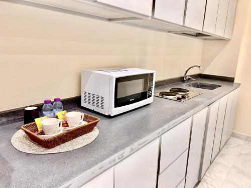 a kitchen counter with a microwave and two baskets at شقة خاصة مؤثثة بالكامل للتأجير اليومي in Hafr Al Baten