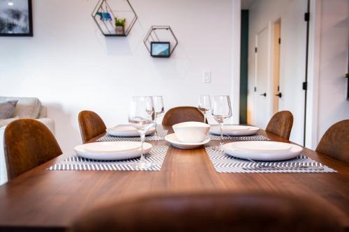a wooden table with chairs and plates and wine glasses at The Three Bear Penthouse - with Hot Tub in Revelstoke