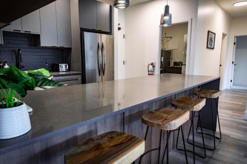 a kitchen with a counter with stools and a refrigerator at The Three Bear Penthouse - with Hot Tub in Revelstoke
