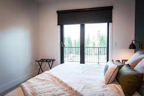 a bedroom with a bed and a large window at The Three Bear Penthouse - with Hot Tub in Revelstoke