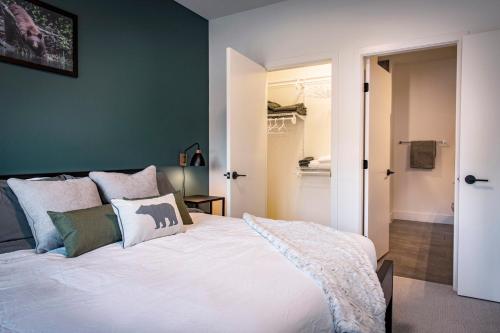 a bedroom with a white bed with a green wall at The Three Bear Penthouse - with Hot Tub in Revelstoke